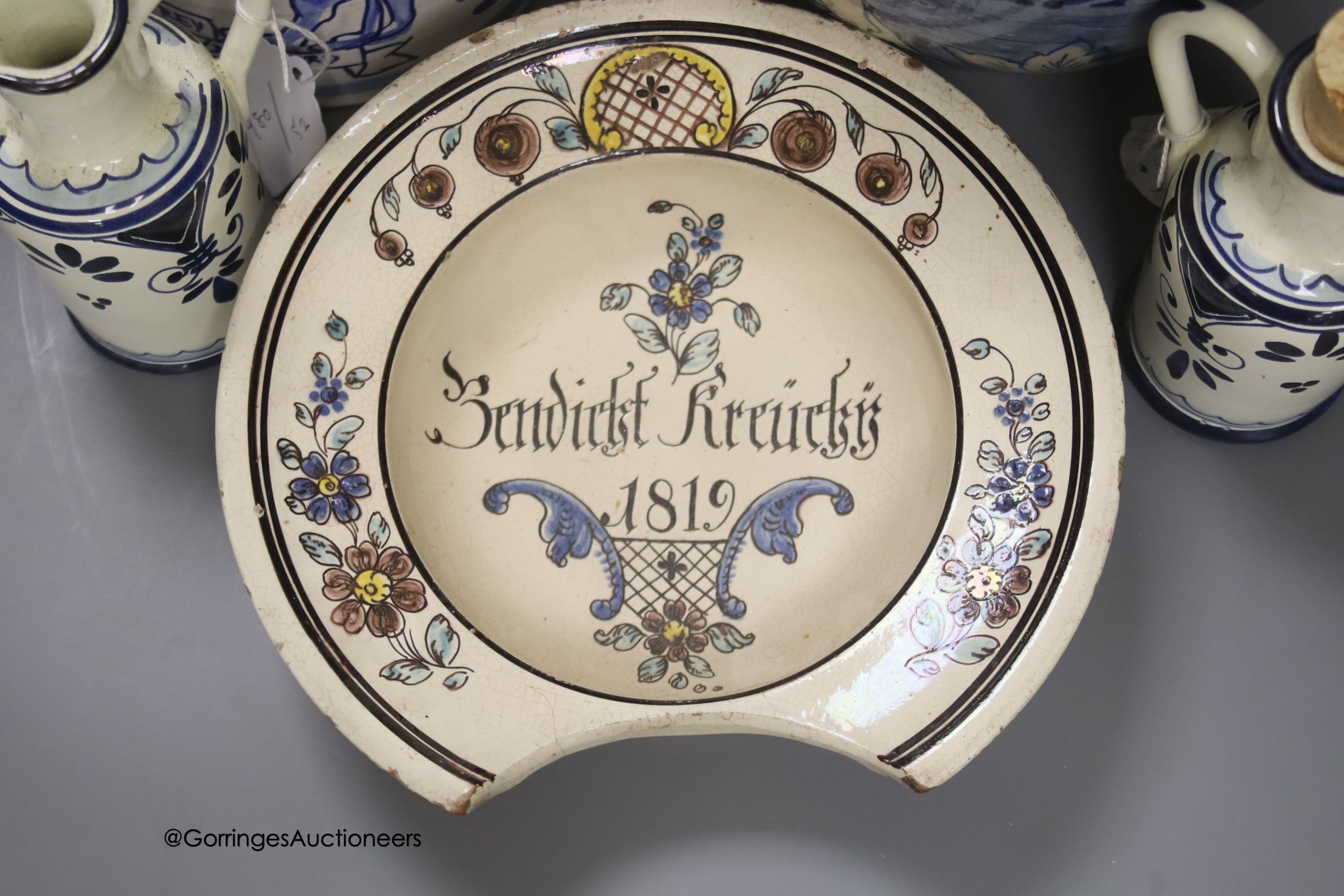 A tin-glazed terracotta barber's bowl dated 1819, a large ovoid eathenware ‘Taback’ jar and three earthenware jugs